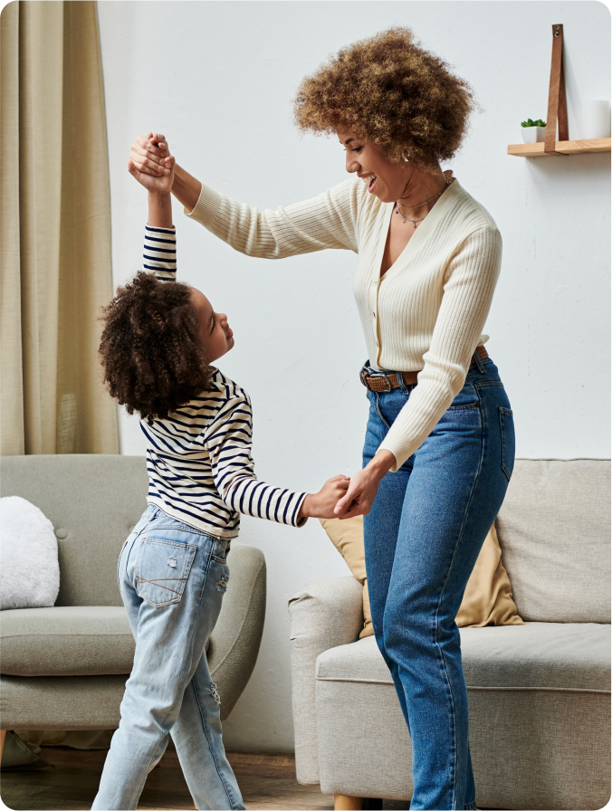 Parent dancing with child in living room
